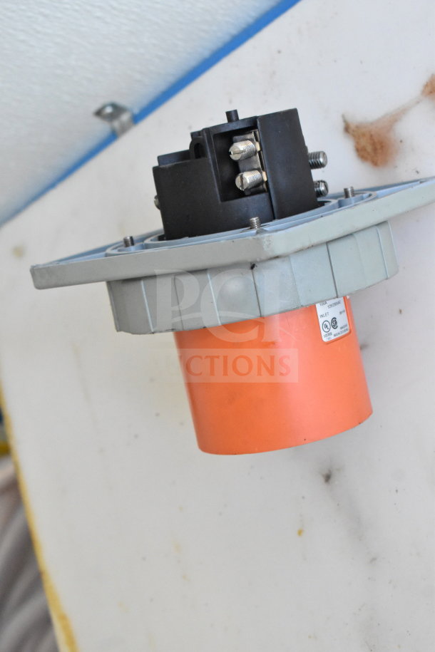 Electrical component with orange and gray casing, mounted on a wall in a food trailer. Visible screws and wiring connections.