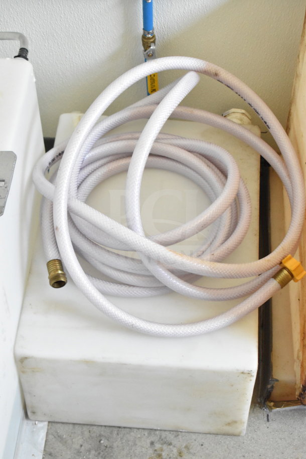 Coiled white hose on a white tank in a 2021 Diamond Cargo 8.5'x24' food trailer, VIN: 53NBE2424M1089867.