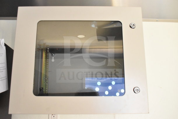 Enclosed electrical panel with a transparent front, mounted on a wall.