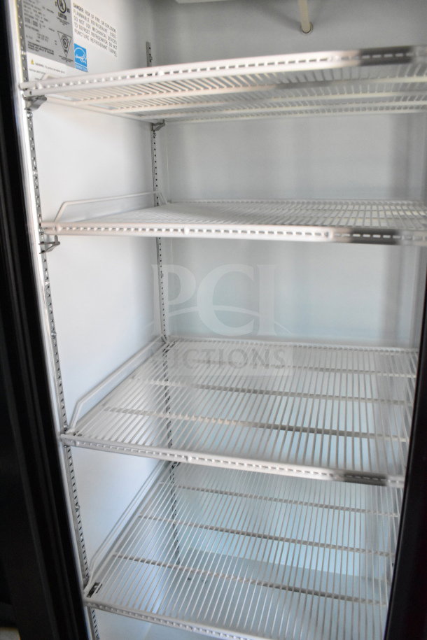 Interior view of Diamond Cargo cold food trailer, showing clean metal shelves and safety label. Ideal for beverage storage.