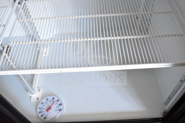 Interior of 2021 Diamond Cargo Cold Food Trailer with wire racks and a dial thermometer. Clean and functional condition.