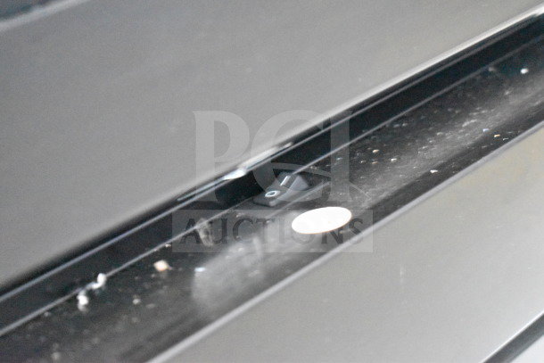 Close-up of the control switch on a 2021 Diamond Cargo 8.5'x24' Cold Food/Beverage Trailer, slightly dusty surface.