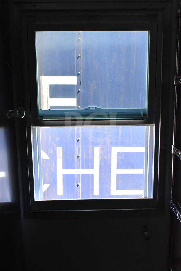 2021 Diamond Cargo 8.5'x24' trailer window view, featuring blue metal siding with white letters.