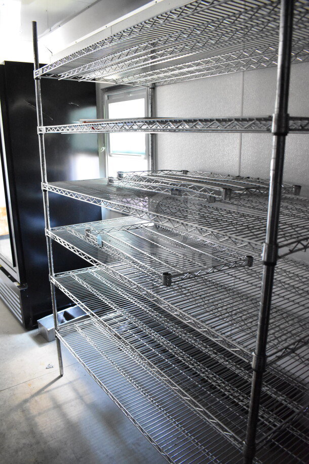 Interior of a 2021 Diamond Cargo 8.5'x24' food/beverage trailer with metal shelving, showing spacious storage capacity.