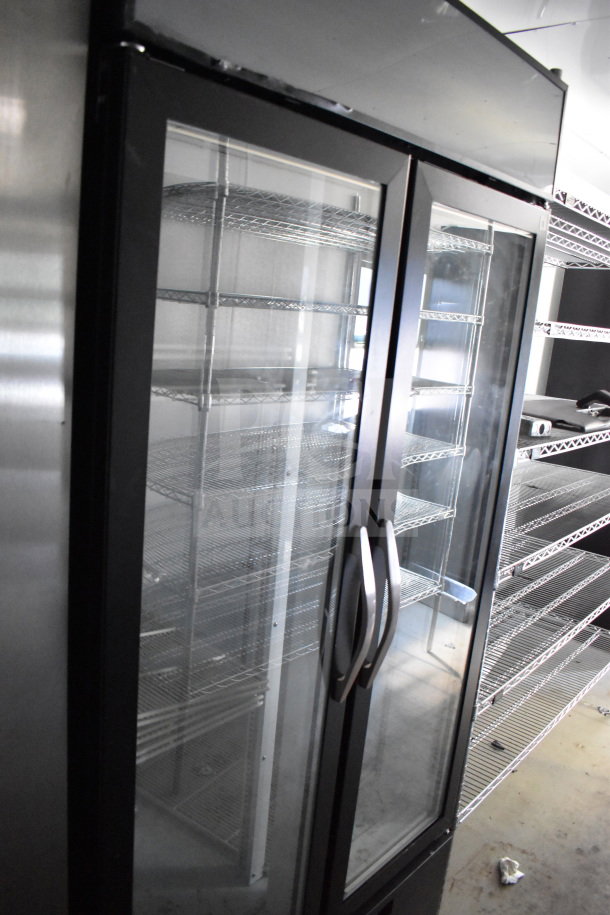 2021 Diamond Cargo 8.5'x24' beverage trailer interior showing stainless steel double-door refrigerator, shelving.