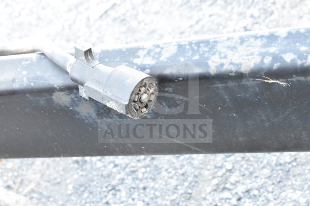 Close-up of trailer connector on Diamond Cargo 8.5'x24' cold food trailer, showing a weathered plug end and metal surface.