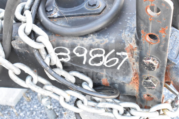 Close-up of trailer hitch on a 2021 Diamond Cargo 8.5'x24' cold food/beverage trailer. Visible chain and VIN 53NBE2424M1089867.