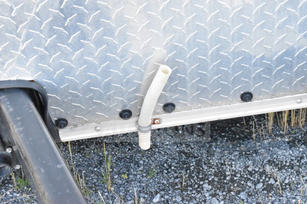 2021 Diamond Cargo 8.5'x24' trailer, metal exterior with drainage hose visible, in good condition.
