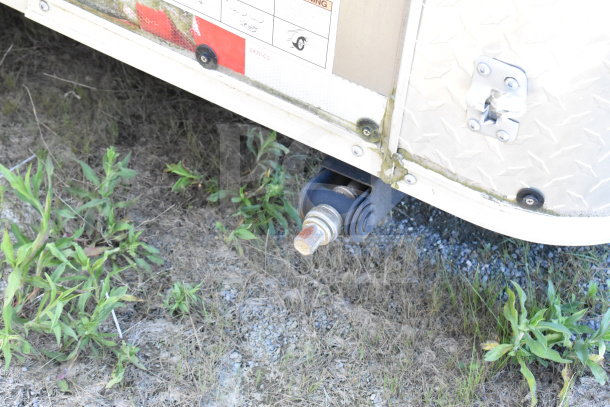 2021 Diamond Cargo 8.5'x24' trailer corner detail, visible safety label, smooth metal finish, rugged terrain.