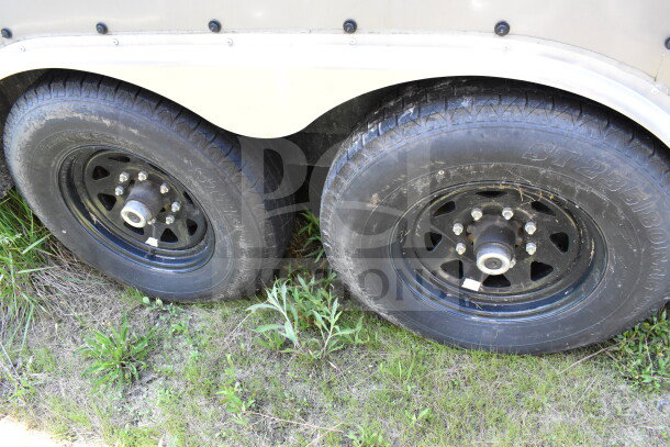 2021 Diamond Cargo 8.5'x24' trailer tires, dual axle, black rims, good condition, grass surface.