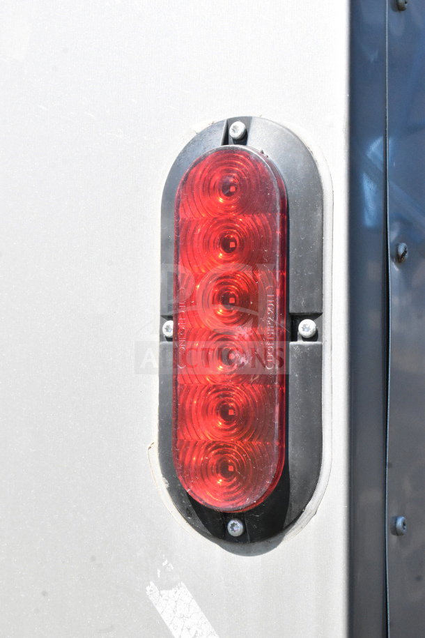 Red tail light of the 2021 Diamond Cargo 8.5'x24' trailer, featuring LED circles in a vertical arrangement on metal casing.