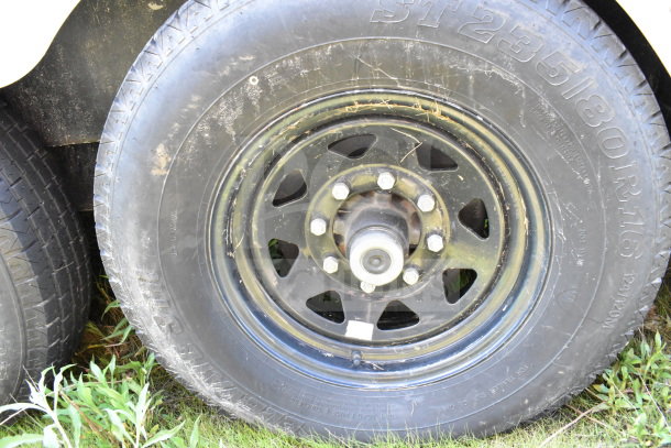 2021 Diamond Cargo 8.5'x24' trailer wheel. Black rim, visible tire markings ST235/80R16. Used condition.