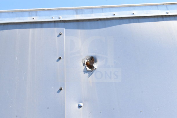 2021 Diamond Cargo 8.5'x24' trailer exterior with visible hole damage. VIN: 53NBE2424M1089867.