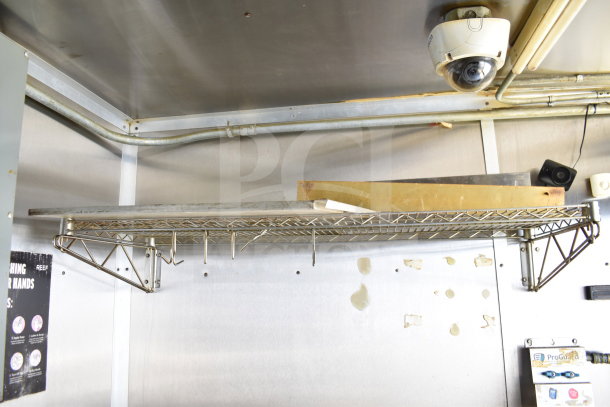 Interior view of a 2019 Diamond Cargo 8.5'x24' food trailer showing wire shelving, a security camera, and stainless steel walls.