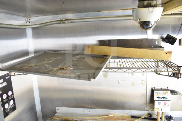 2019 Diamond Cargo 8.5'x24' food trailer interior; grease hood, shelving, and surveillance camera visible. Used condition.