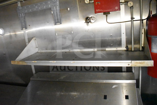 2019 Diamond Cargo 8.5'x24' food trailer interior with grease hood and red fire suppression system, stainless steel shelving.