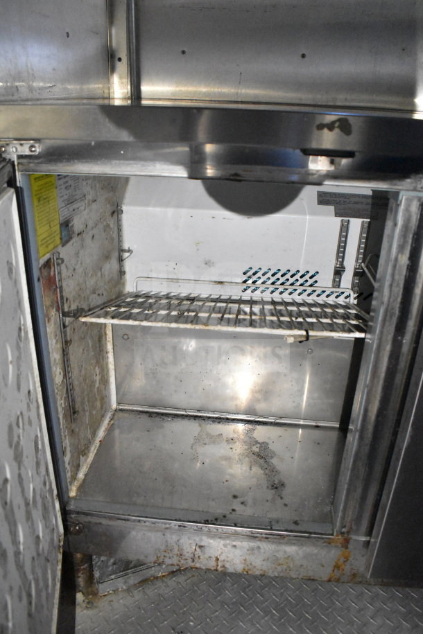 2019 Diamond Cargo 8.5'x24' food trailer interior with shelving. Some rust and wear visible. Equipped with grease hood and suppression system.