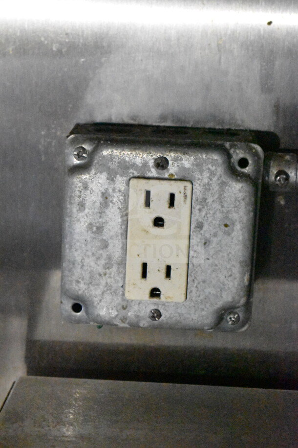 Electrical outlet inside a 2019 Diamond Cargo 8.5'x24' food trailer. The outlet is mounted on a metallic surface, showing signs of age.