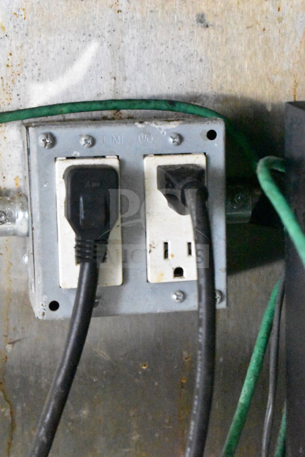 Close-up of electrical outlets in a 2019 Diamond Cargo 8.5'x24' food trailer. Outlets with attached cables, lightly worn.