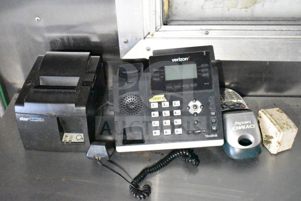 Office equipment includes a Verizon Yealink T41S phone, Star TSP100III thermal printer, Dymo label maker, and an electrical adapter on a countertop.