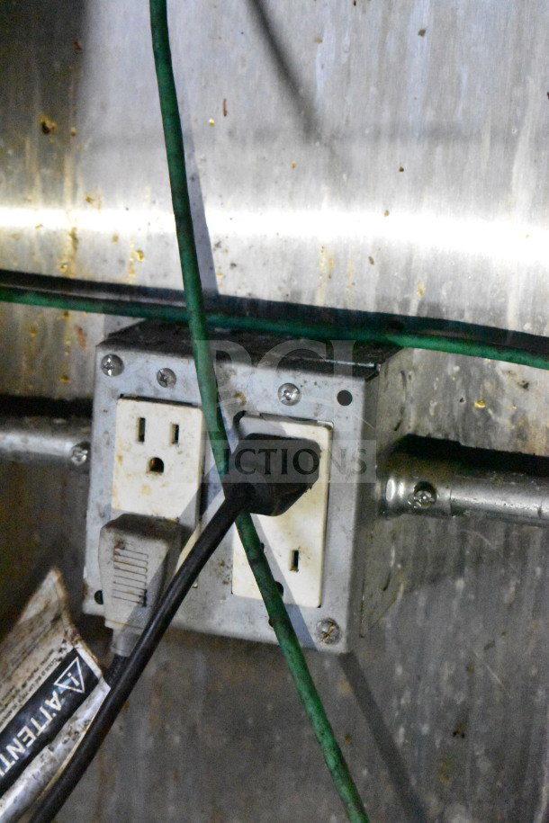 Power outlet with multiple cables connected, indicative of electrical functionality inside a 2019 Diamond Cargo food trailer.