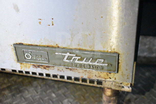 Close-up of a worn True Refrigerator label with natural refrigerant marking on a 2019 Diamond Cargo 8.5'x24' food trailer.