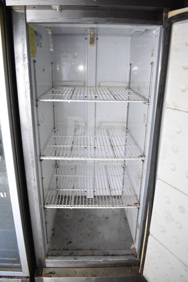 Interior of a refrigeration unit inside a 2019 Diamond Cargo food trailer, featuring wire shelves and showing signs of use.