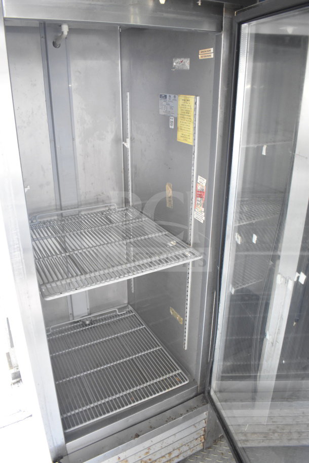 Interior view of a 2019 Diamond Cargo food trailer showing empty refrigeration unit with wire shelves and visible safety labels.