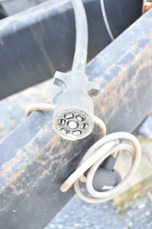 Close-up of a wiring connector and coiled cables on the 2019 Diamond Cargo food trailer frame. Condition appears used.