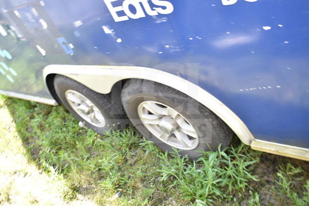 2019 Diamond Cargo 8.5'x24' food trailer side view, showing dual tires. Blue exterior, minor wear visible. 
