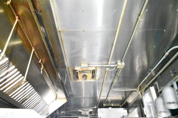 2020 LGS TX 8.5'x24' food trailer interior with CaptiveAire grease hood, suppression system, visible ceiling piping.