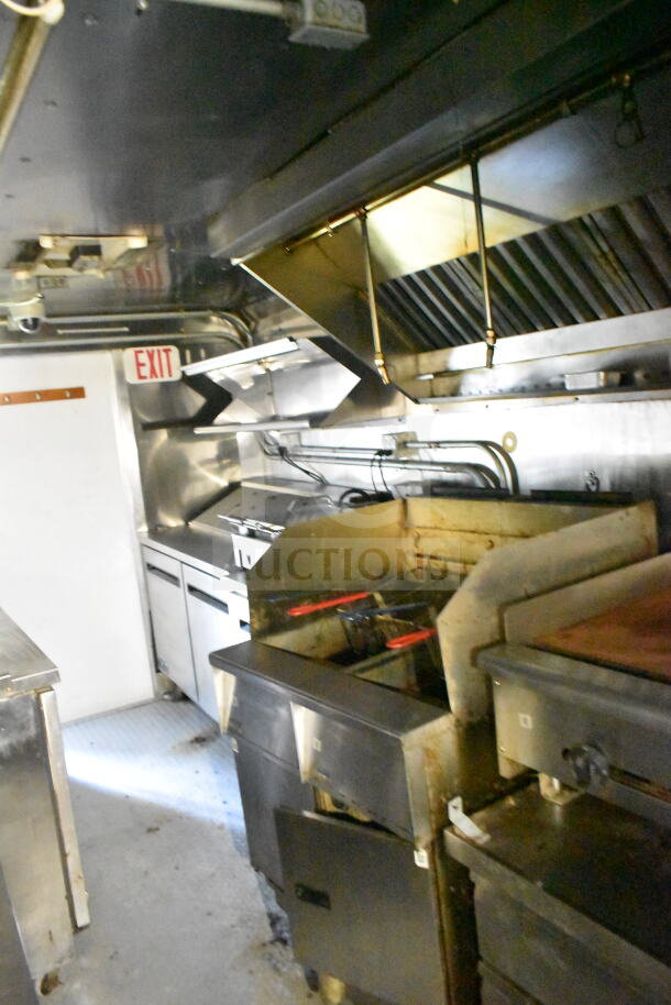 2020 LGS TX 8.5'x24' food trailer interior featuring CaptiveAire grease hood, suppression system, griddle, and refrigeration.