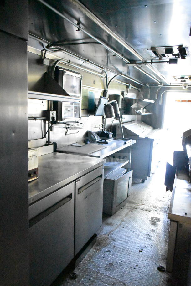 2020 LGS TX 8.5'x24' food trailer interior with CaptiveAire grease hood, refrigeration, griddle. Stainless steel counters.