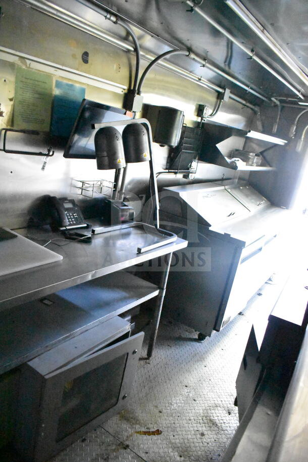 2020 LGS TX 8.5'x24' food trailer interior with CaptiveAire grease hood, suppression system, refrigeration, and griddle.
