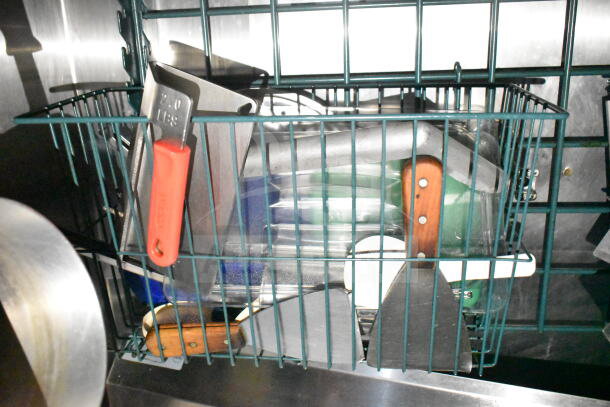 Kitchen utensils in a metal rack inside the 2020 LGS TX food trailer. Visible: spatulas, scoops, and knives.