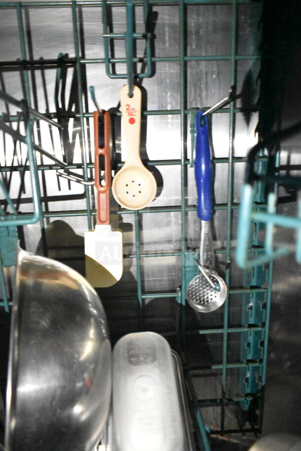 Kitchen tools and utensils hanging on a metal rack inside a 2020 LGS TX 8.5'x24' food trailer.