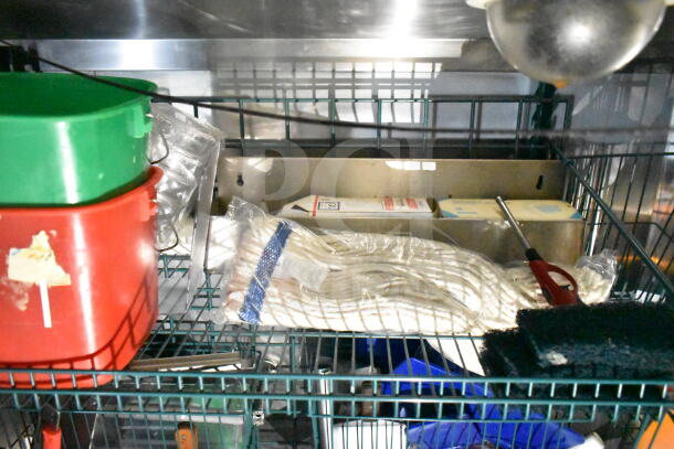 Inside view of 2020 LGS TX food trailer showing storage shelves with cleaning supplies, utensils, and a lighter.