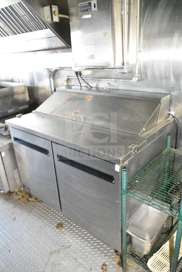 2020 LGS TX 8.5'x24' food trailer interior with CaptiveAire grease hood, suppression system, refrigeration, and griddle.
