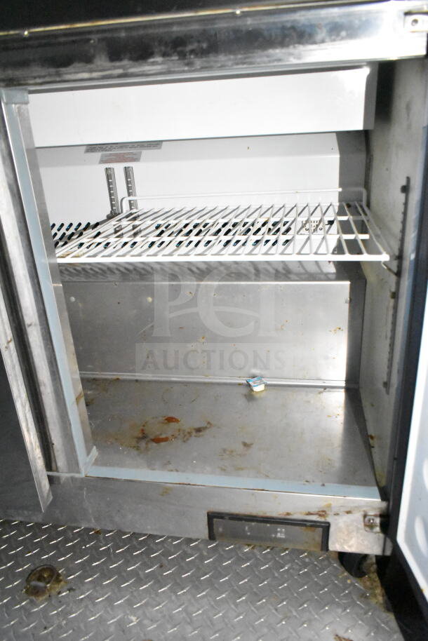 2020 LGS TX food trailer interior showing refrigeration unit with wire shelves. Visible wear and grime on surfaces.