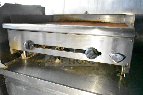 Stainless steel griddle inside 2020 LGS TX food trailer, showing control knobs and cooking surface.