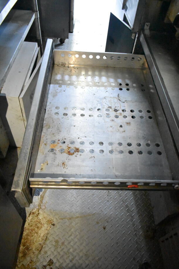 2020 LGS TX food trailer interior, showing metal storage shelf. Visible wear and perforated design enhance ventilation.