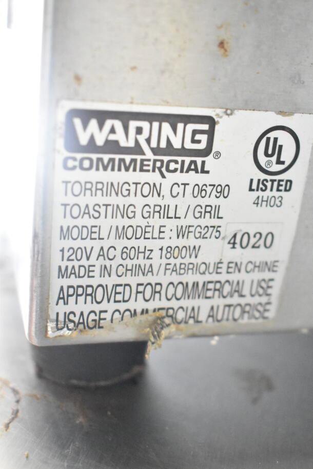 "Image of a label from a Waring Commercial Toasting Grill, Model WFG275, 120V AC 60Hz 1800W, approved for commercial use."