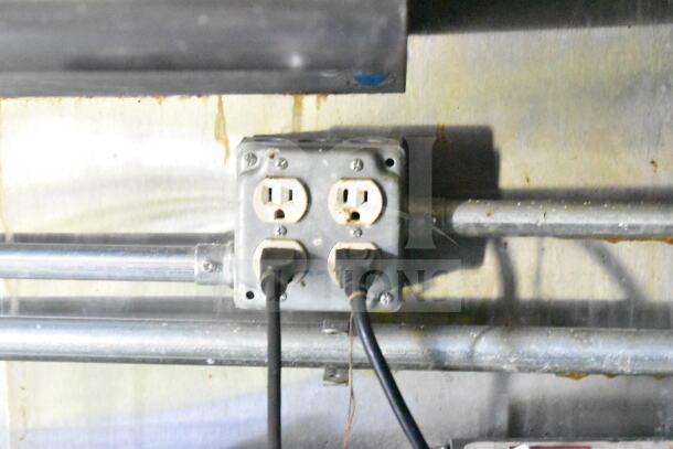 Electrical outlet with two plugs in the interior of a 2020 LGS TX 8.5'x24' food trailer. Visible metal conduit and cables.