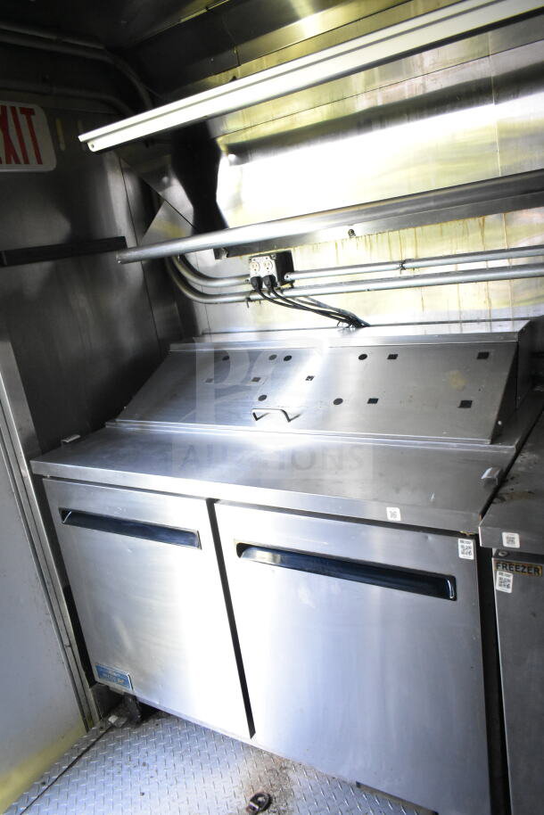 2020 LGS TX 8.5'x24' food trailer interior featuring CaptiveAire grease hood, refrigeration units, and a griddle area.