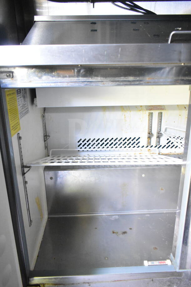 Interior view of a 2020 LGS TX food trailer showing stainless steel refrigeration, visible wear, and a safety label.
