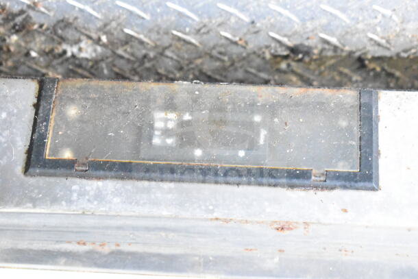 Close-up of a metal section on the 2020 LGS TX 8.5'x24' food trailer. VIN: 53BPTEB26MR003733 visible in a worn condition.