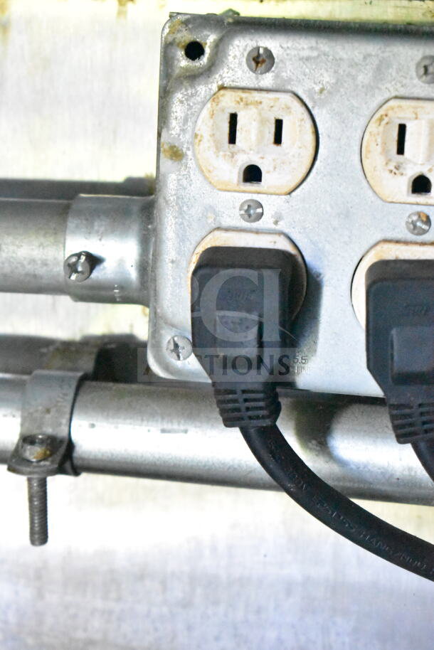 Close-up of an electrical outlet with plugged-in cables inside a 2020 LGS TX 8.5'x24' food trailer.
