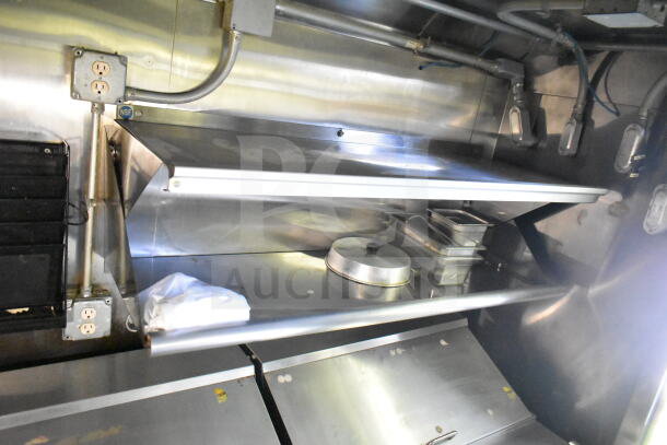 2020 LGS TX 8.5'x24' food trailer interior with CaptiveAire grease hood, shelving, and stainless steel surfaces.