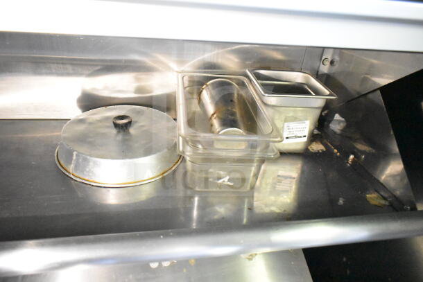 2020 LGS TX food trailer interior showing stainless steel containers and lids, highlighting kitchen setup.