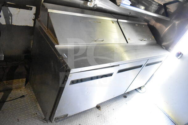 2020 LGS TX 8.5'x24' food trailer interior showing stainless steel refrigeration units, grease hood, and griddle.